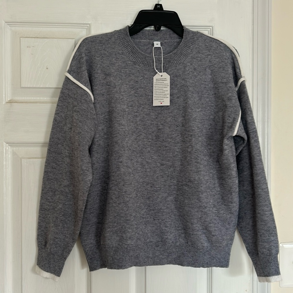 Sweater with white trim on shoulders and wrist line